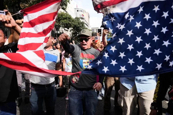 Government supporters rip an American flag in half during a protest in Caracas, Venezuela, Saturday, Jan. 3, 2026, after U.S. President Donald Trump announced that U.S. forces had captured President Nicolás Maduro and first lady Cilia Flores. (AP Photo/Ariana Cubillos)