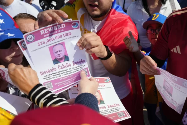 Reward posters are passed out at a gathering celebrating the deposing of Venezuelan President Nicolás Maduro, Sunday, Jan. 4, 2026, in Katy, Texas. (Elizabeth Conley/Houston Chronicle via AP)